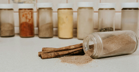 A jar of ground cinnamon lays on its side