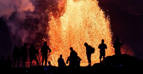 People watching Hawaii's Kilauea Volcano eruption on May 11, 2025. (Cover Image Source: Getty Images | Photo By Gary Miller)