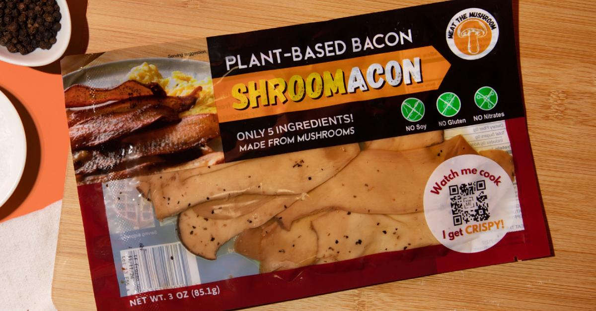 Product image of Meat The Mushroom's plant-based SHROOMACON on a wooden surface