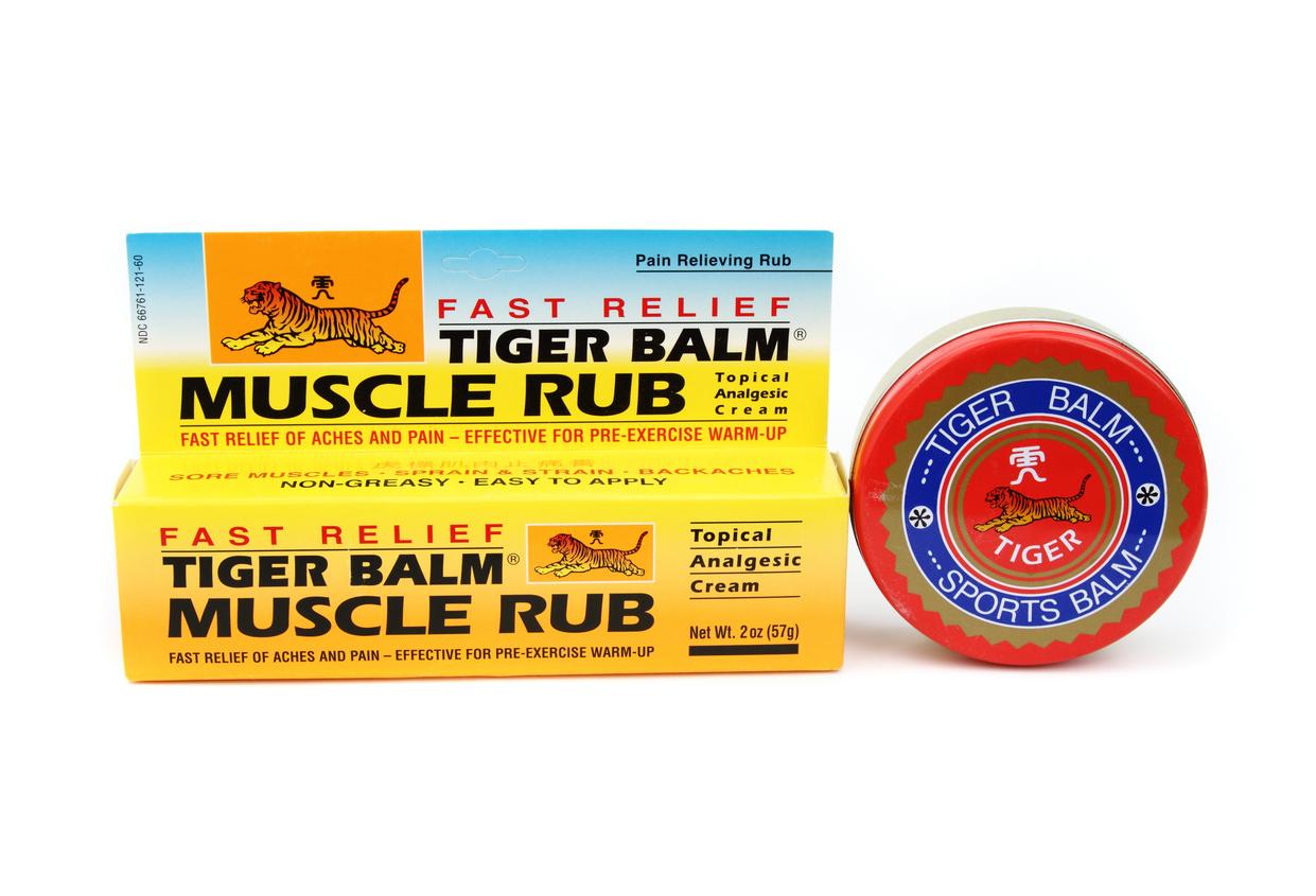 A package of Tiger Balm's "Muscle Rub" product is pictured beside a can of the "Sports Balm" product.