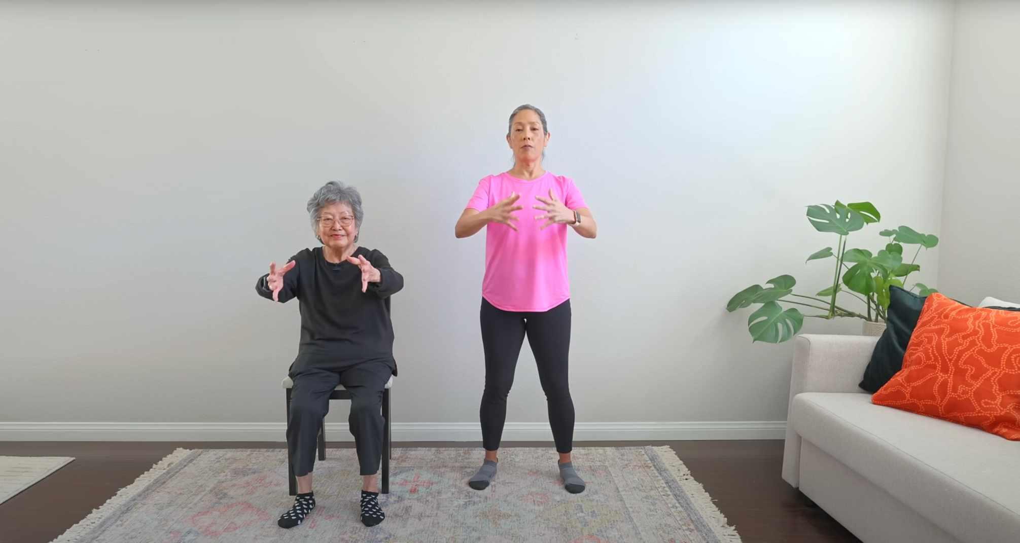 Two older adults perform standing and seated Tai Chi movements.