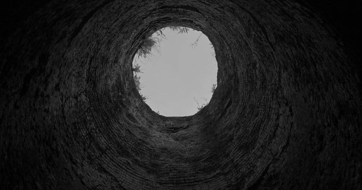 A view of the sky from inside a deep, dark manmade hole. (Representative Cover Image Source: Pexels | Agustin Fernandez)