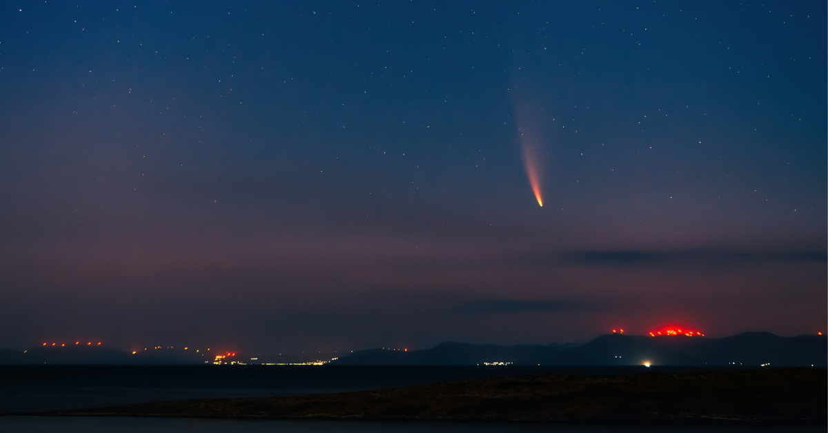 A meteor can be seen flying across the night sky