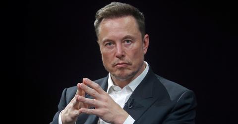 Elon Musk sits in front of a black background, holding his hands together, at the Viva Technology conference at the Porte de Versailles exhibition centre on June 16, 2023 in Paris, France.