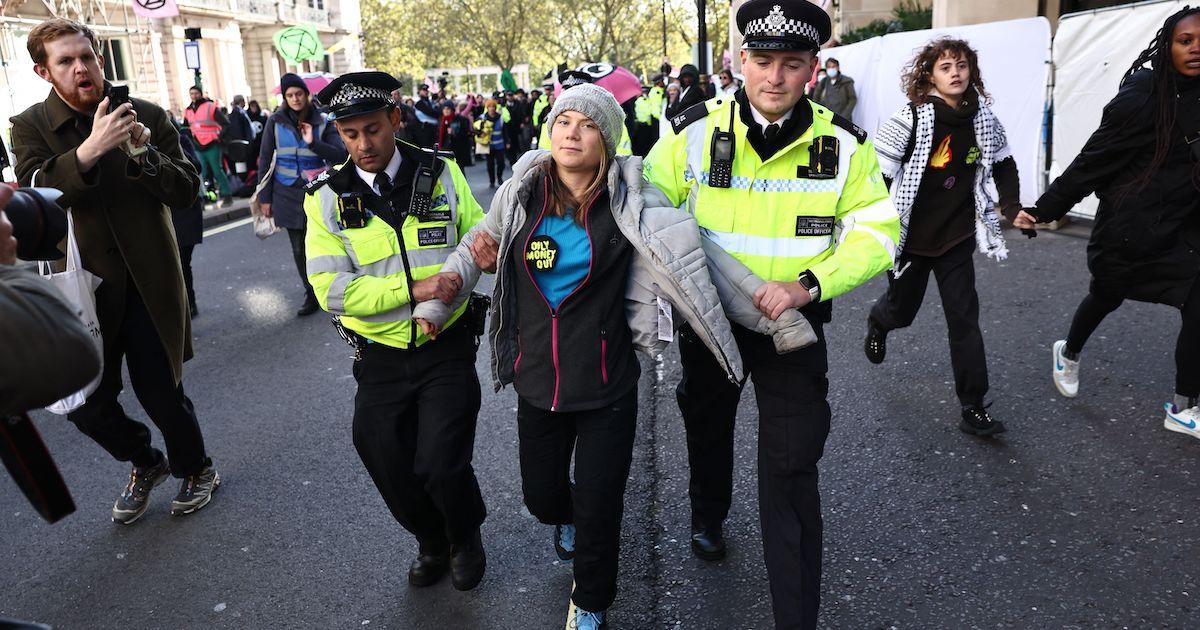 Greta Thunberg being walked by two policemen while under arrest