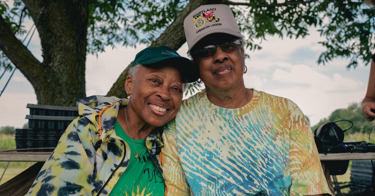 Paulette Greene and Donna Dear smile at the camera from their farm