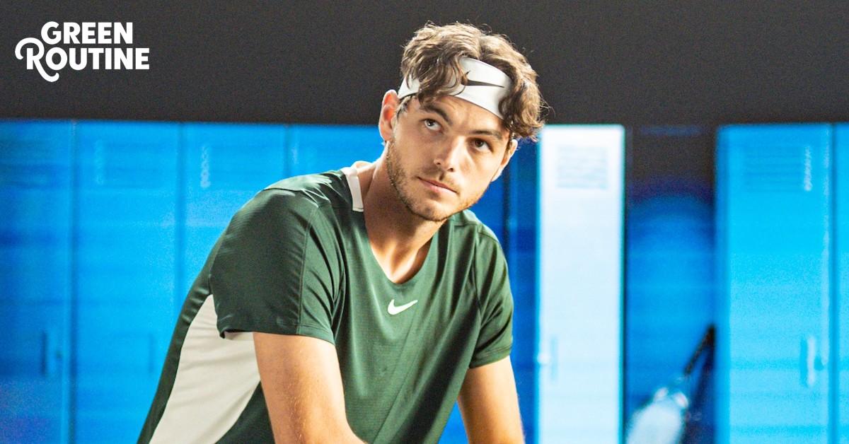 Taylor Fritz wears a green T-shirt and white headband