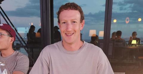 Mark Zuckerberg sits at a table with beef out of frame, with the sky seen in the reflection in the background