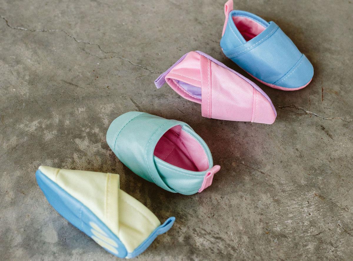 Woolybubs baby shoes in four colors on cement surface