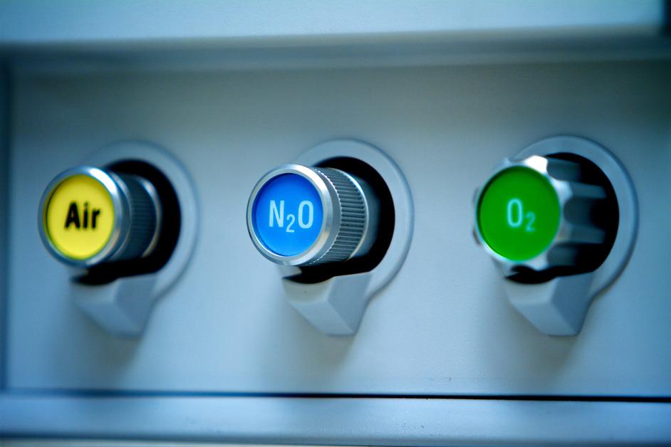 A close photo of air, nitrous oxide, and oxygen buttons on an anesthesia machine in an operating room in a hospital.