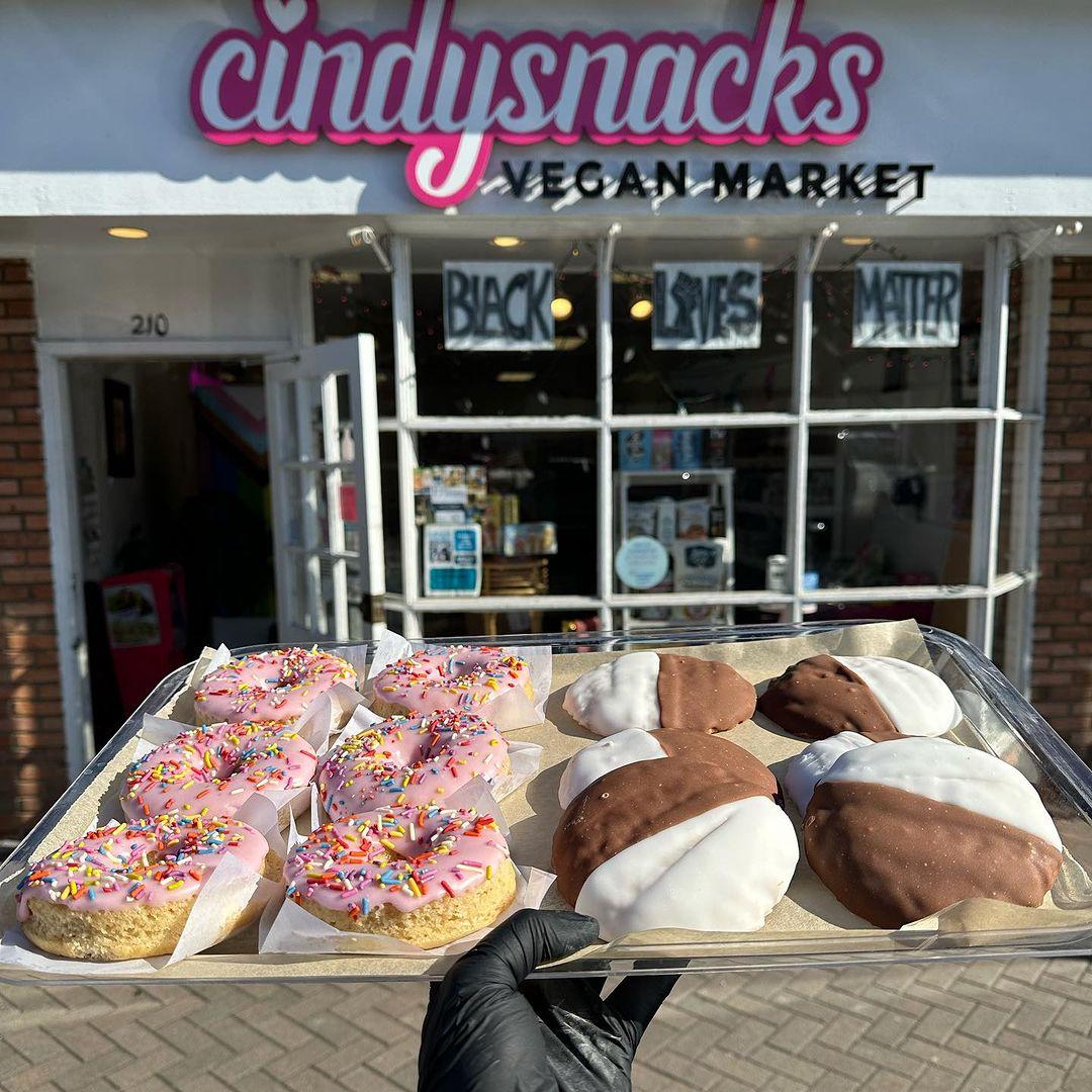 A variety of vegan baked goods are displayed in front of the storefront for Cindysnacks in New York.