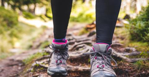 Close up of person wearing hiking boots on trail
