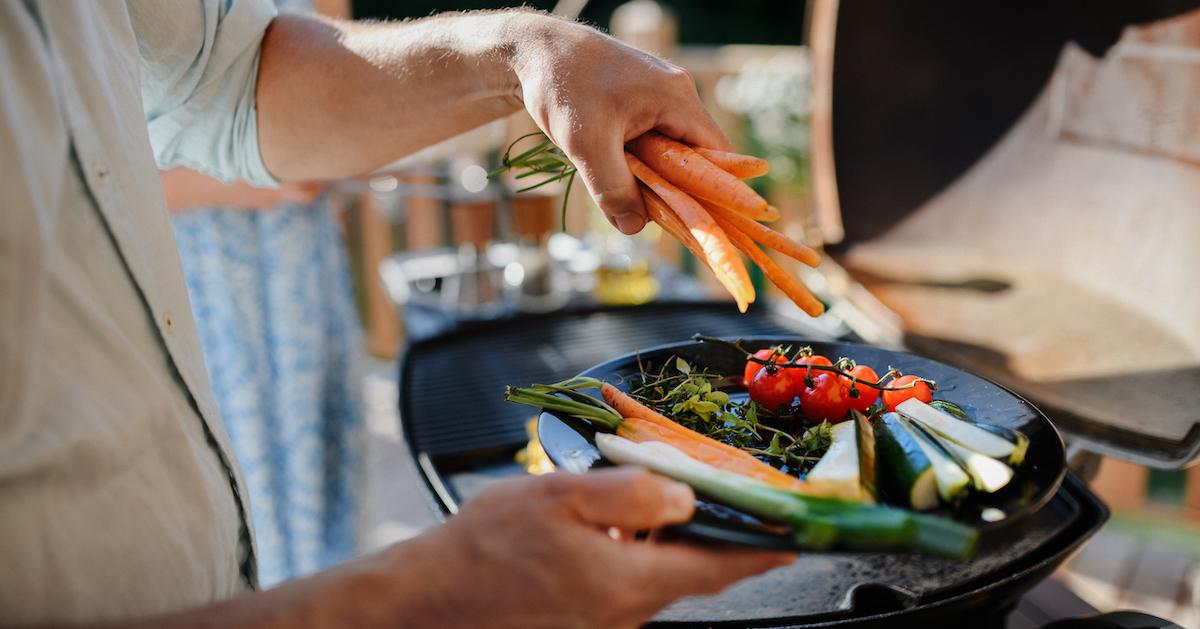 A man preparing vegetables for grilling