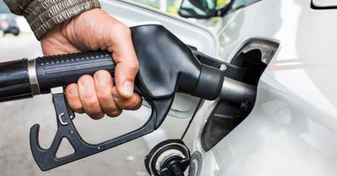 Mans's hand holding fuel nozzle in car. (Representative Cover Image Source: Getty Images | Dimitri Otis)