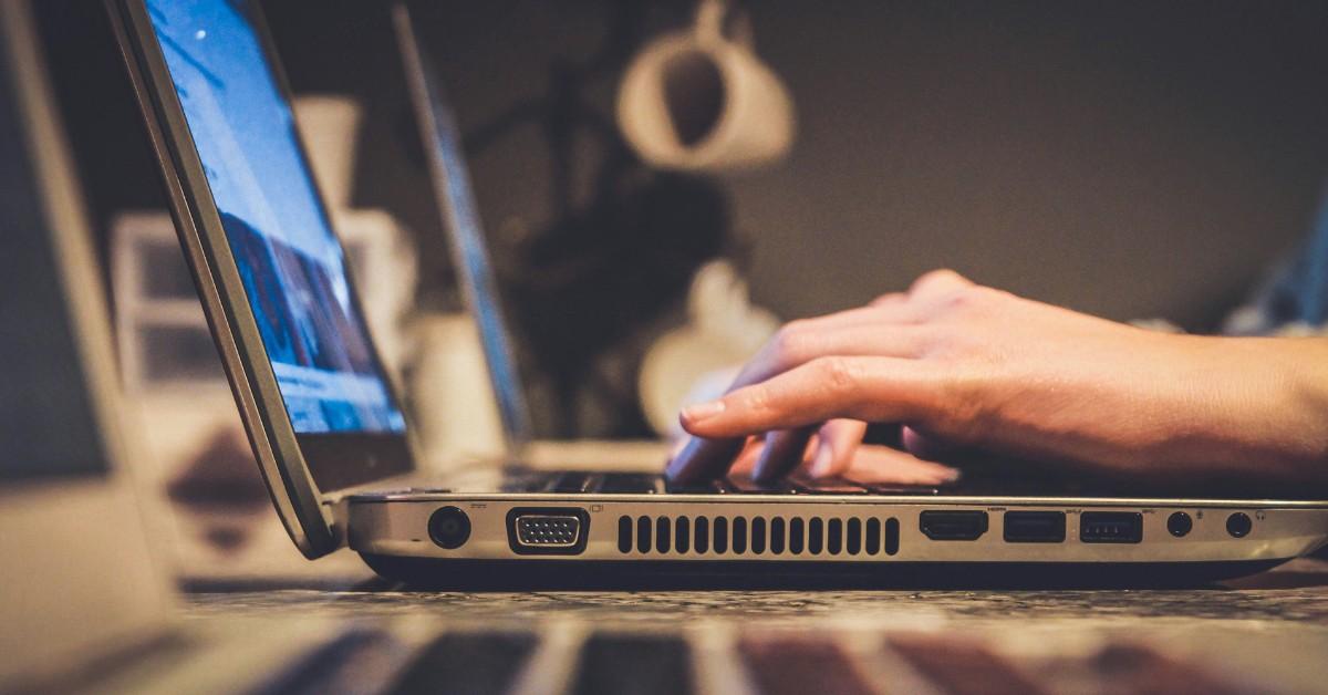 A person types on a laptop