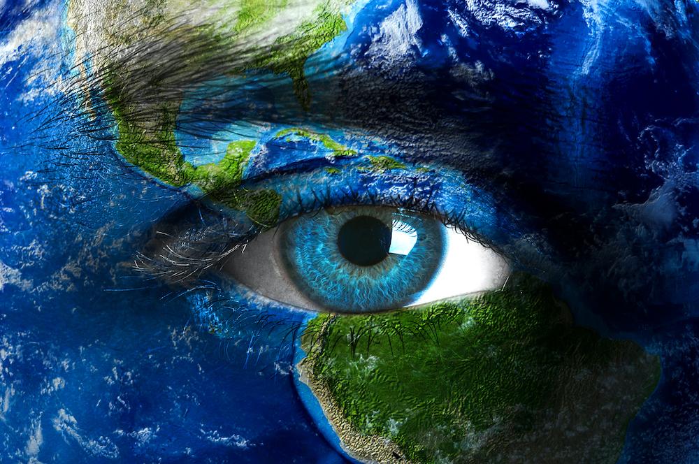 An close up of a blue eye and Earth. 