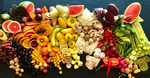 Colorful fruits, vegetables, and nuts lay against a black backdrop