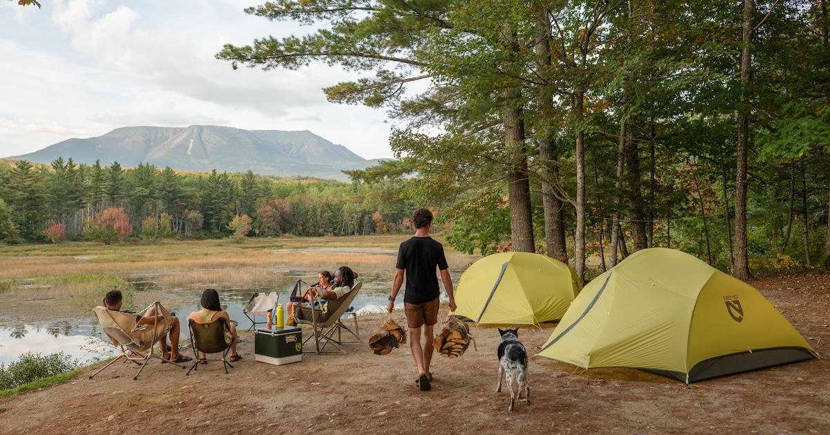 Outdoor scene featuring NEMO Outdoor tents and people in camping chairs