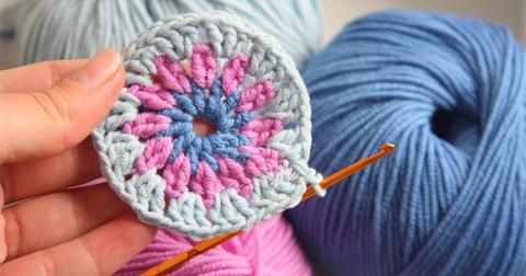 Close up of a blue and pink crochet circle.