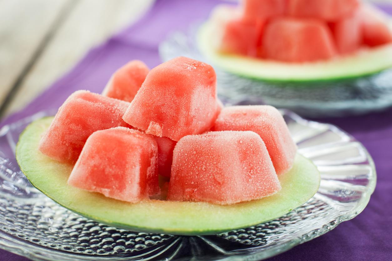 Frozen cubed watermelon on a rind on a plate.