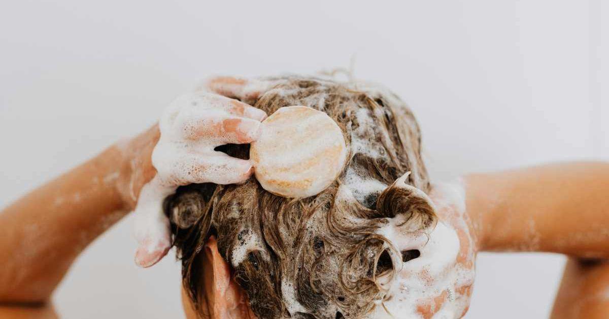 A woman washing her hair with a shampoo bar. (Representative Cover Image Source: Pexels | Kaboompics.com)