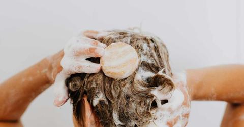 A woman washing her hair with a shampoo bar. (Representative Cover Image Source: Pexels | Kaboompics.com)