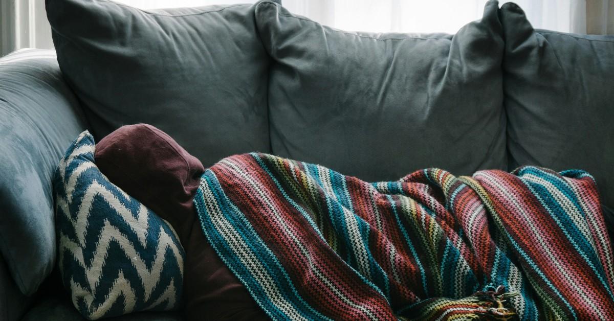 A sick person lays on the sofa