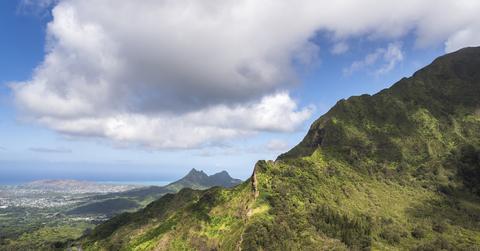 A photo taken from a high angle of the sun on the side of a mountain in Oahu.