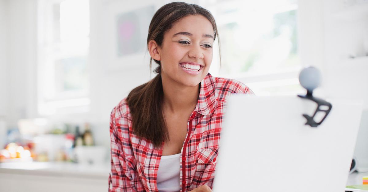 A woman laughing on a video call.