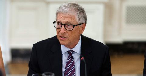 Bill Gates speaks into a microphone while wearing a suit