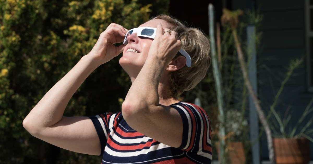 Woman watching an eclipse through solar eclipse glasses (Representative Cover Image Source: Getty Images | Spider Play)