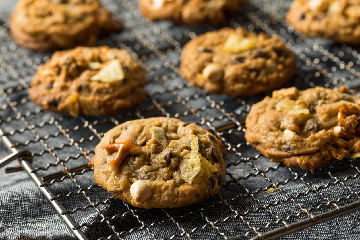 Everything but the kitchen sink cookies — a dessert with random pantry ingredients like potato chips and pretzels — on a cooling rack.