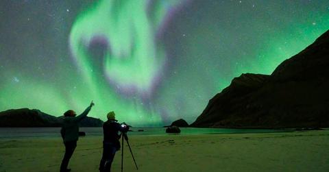 Two people looking at auroras in the sky. (Representative Cover Image Source: Getty Images | Roberto Moiola)