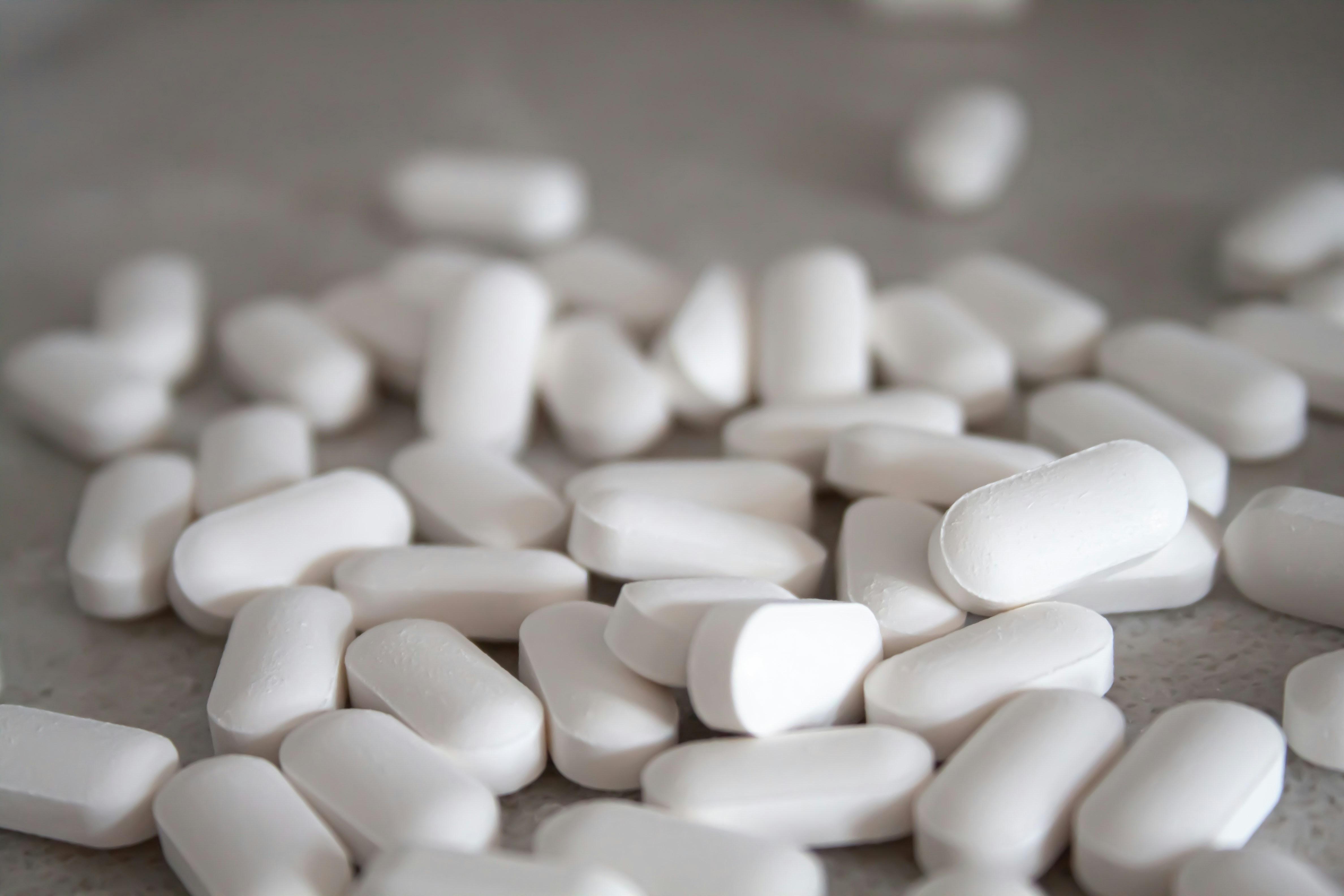 White Acetaminophen tablets are pictured stacked beside one another.