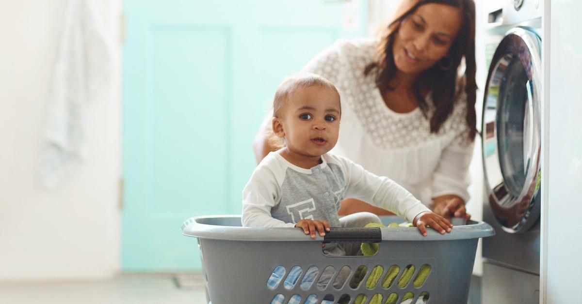 Baby in a laundry basket with mother in the laundry room