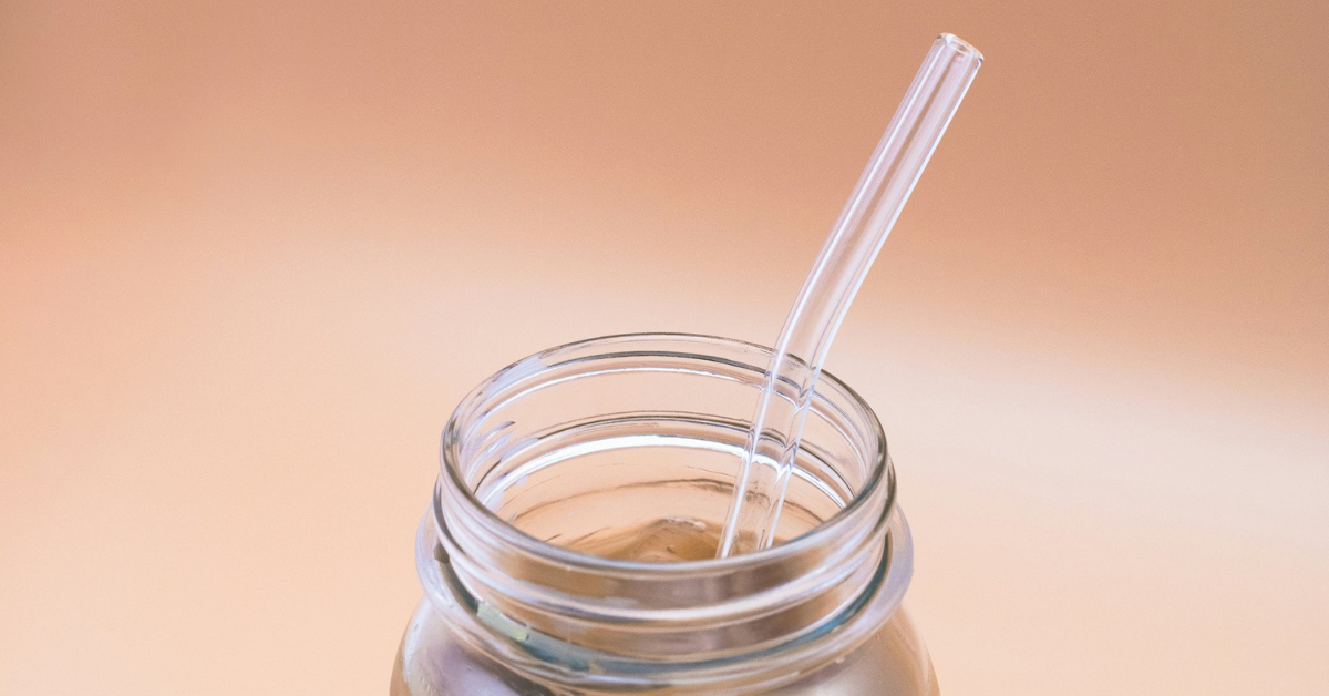 Closeup of a mason jar with a glass straw