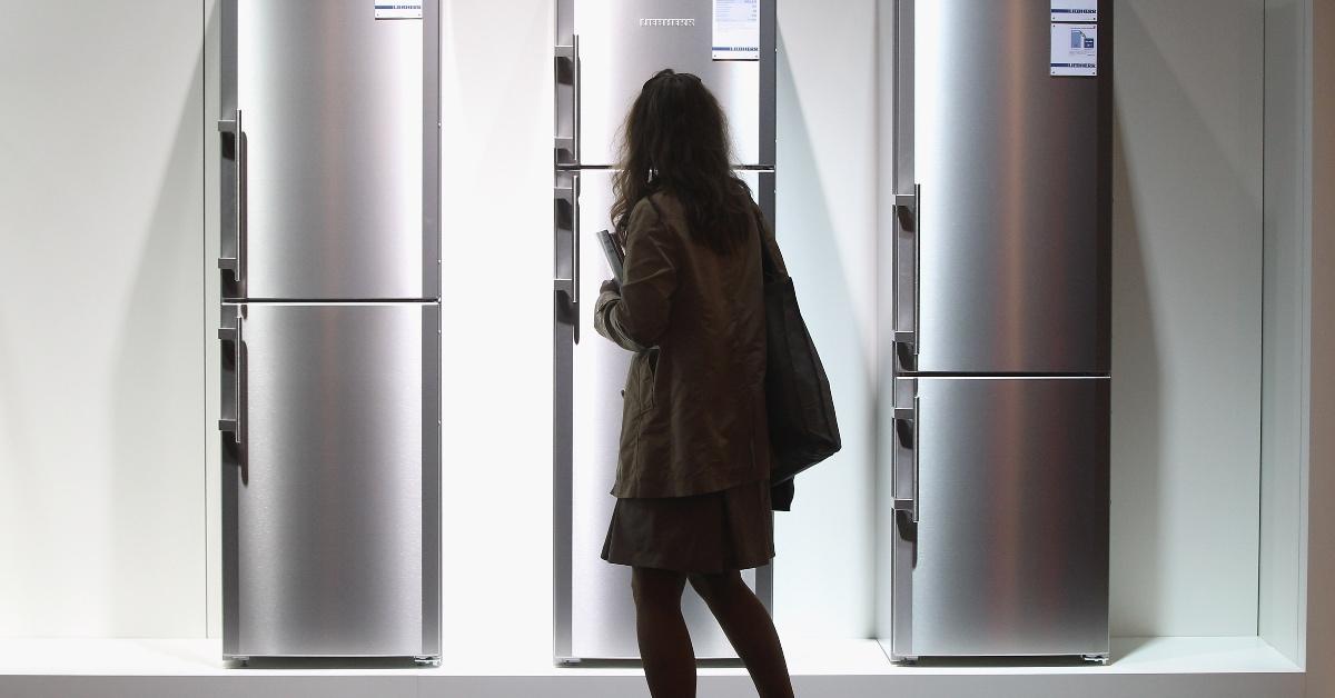 A photo of a woman looking at refrigerators