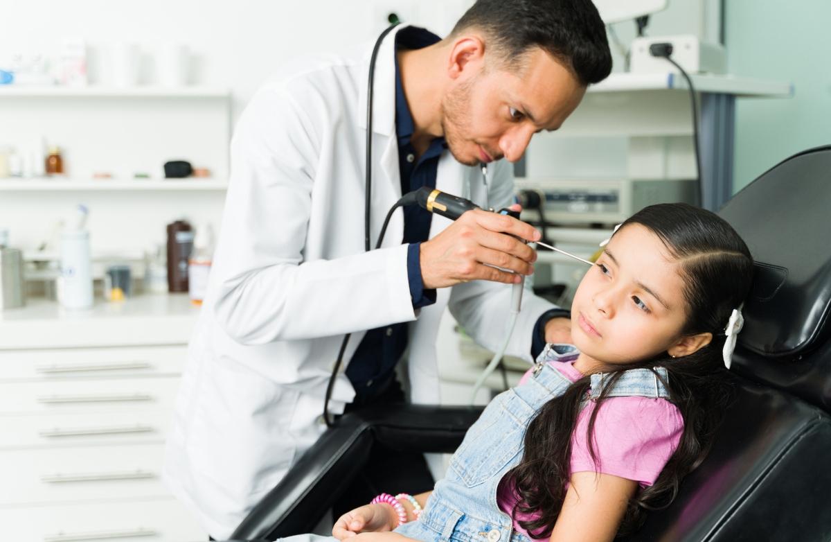 Doctor examining a female patient's ears