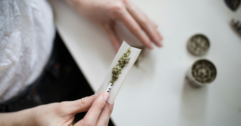 A person rolls weed in paper