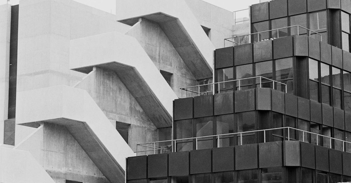 Two eco brutalism style buildings, in black and white