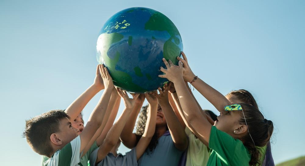 A group of kids holding up the Earth.