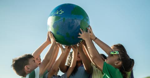 A group of kids holding up the Earth.