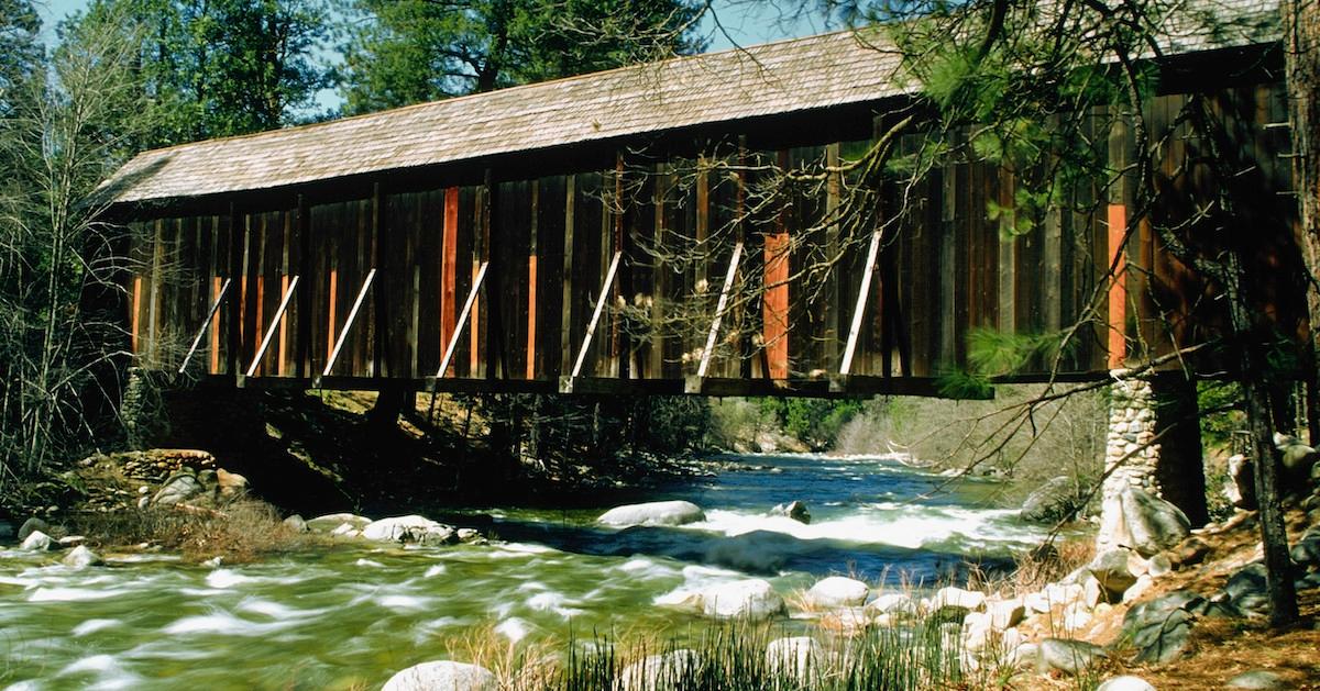 Yosemite's river flowing quickly underneath a covered bridge.