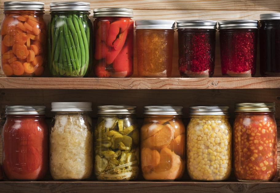 Two shelves of preserved foods in jars. 