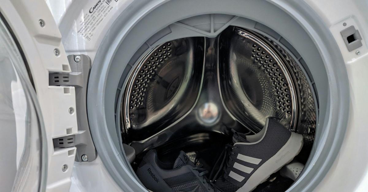 A front load washing machine sits open showing off the gaskets that need to be scrubbed down to prevent smells