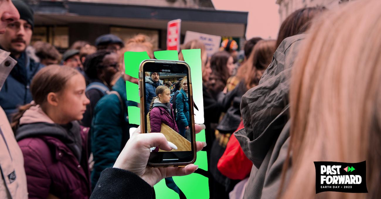 A hand using an iPhone films Greta Thunberg during a protest.