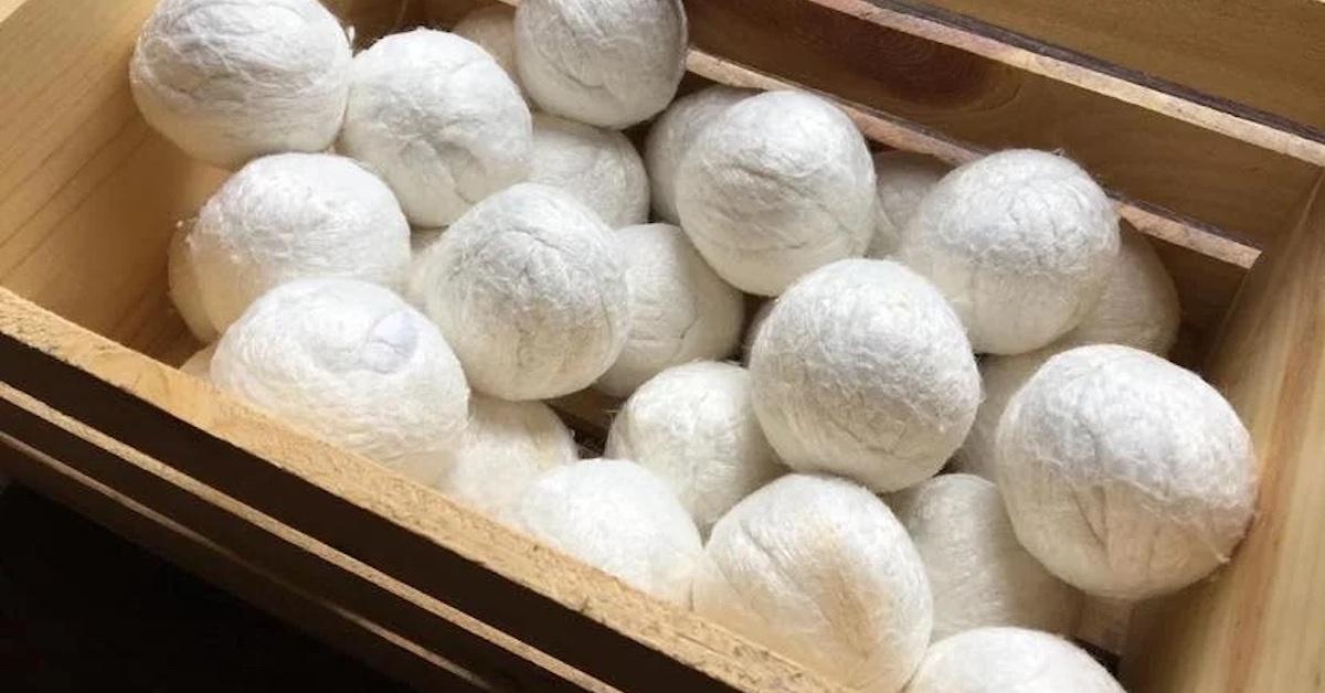 PIle of white vegan dryer balls in a wooden basket