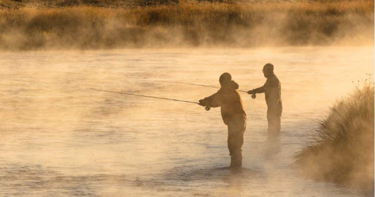 Silhouettes of visitors engaged in fishing in Yellowstone with waters shining golden in sunlight (Cover Image Source: Instagram | @YellowstoneNPS)