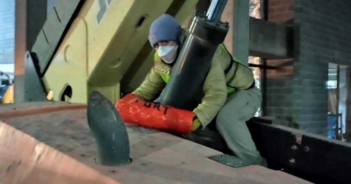 A local Stop Cop City activist uses a reinforced pipe to lock themselves to construction equipment.