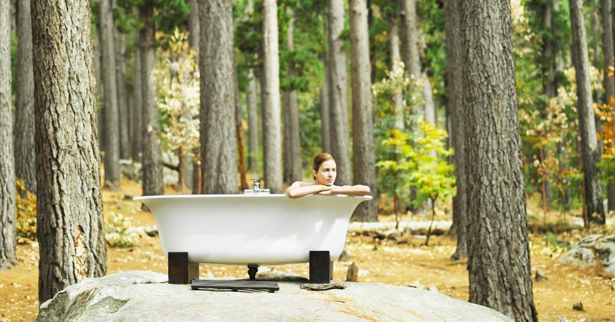 Woman soaks in a bath in the middle of the woods